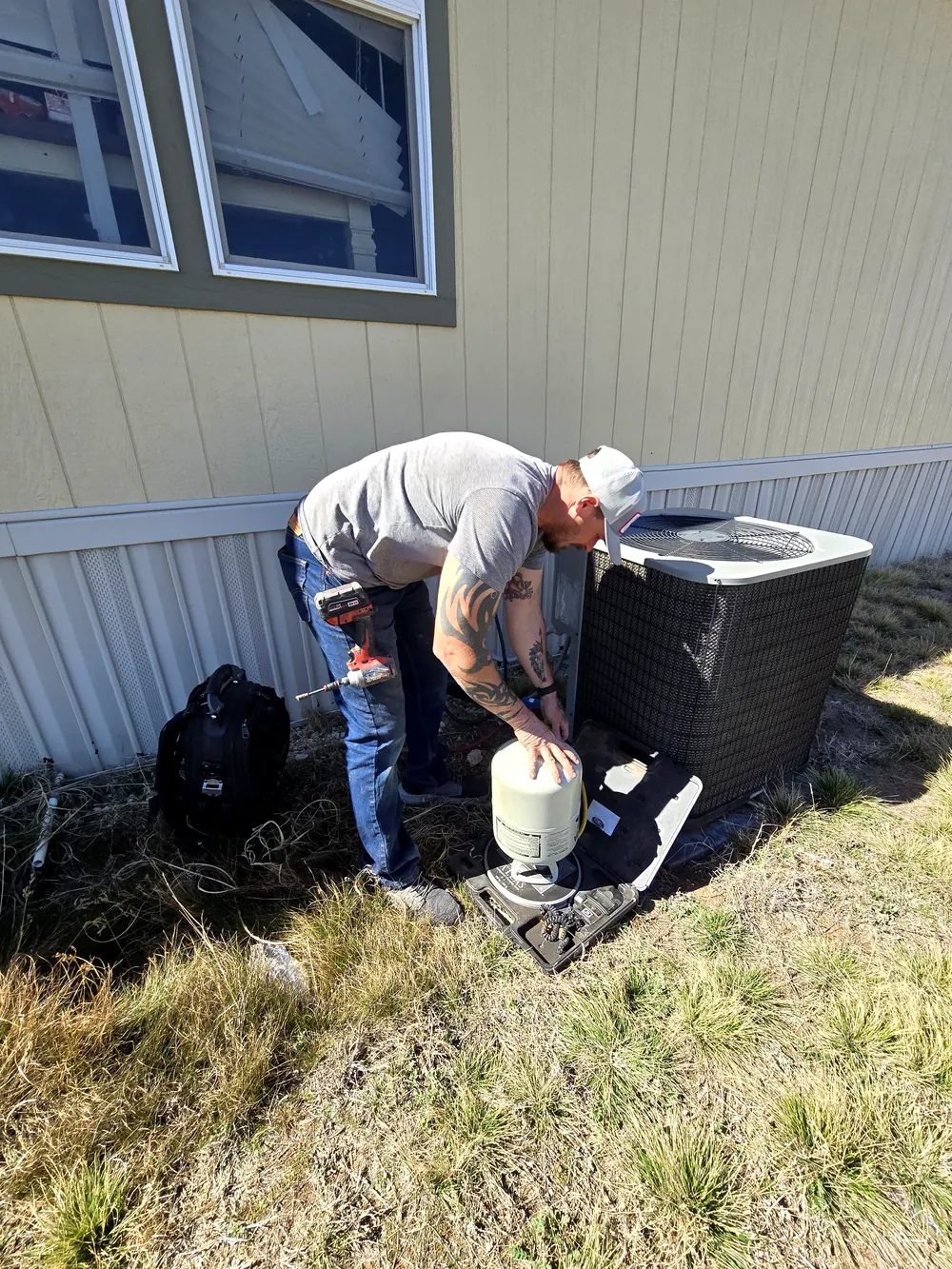 Hawkins technician installing an outdoor AC unit at an Abilene home